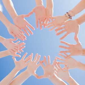 togetherness, team, union, people and gesture concept - close up of many hands over blue sky background